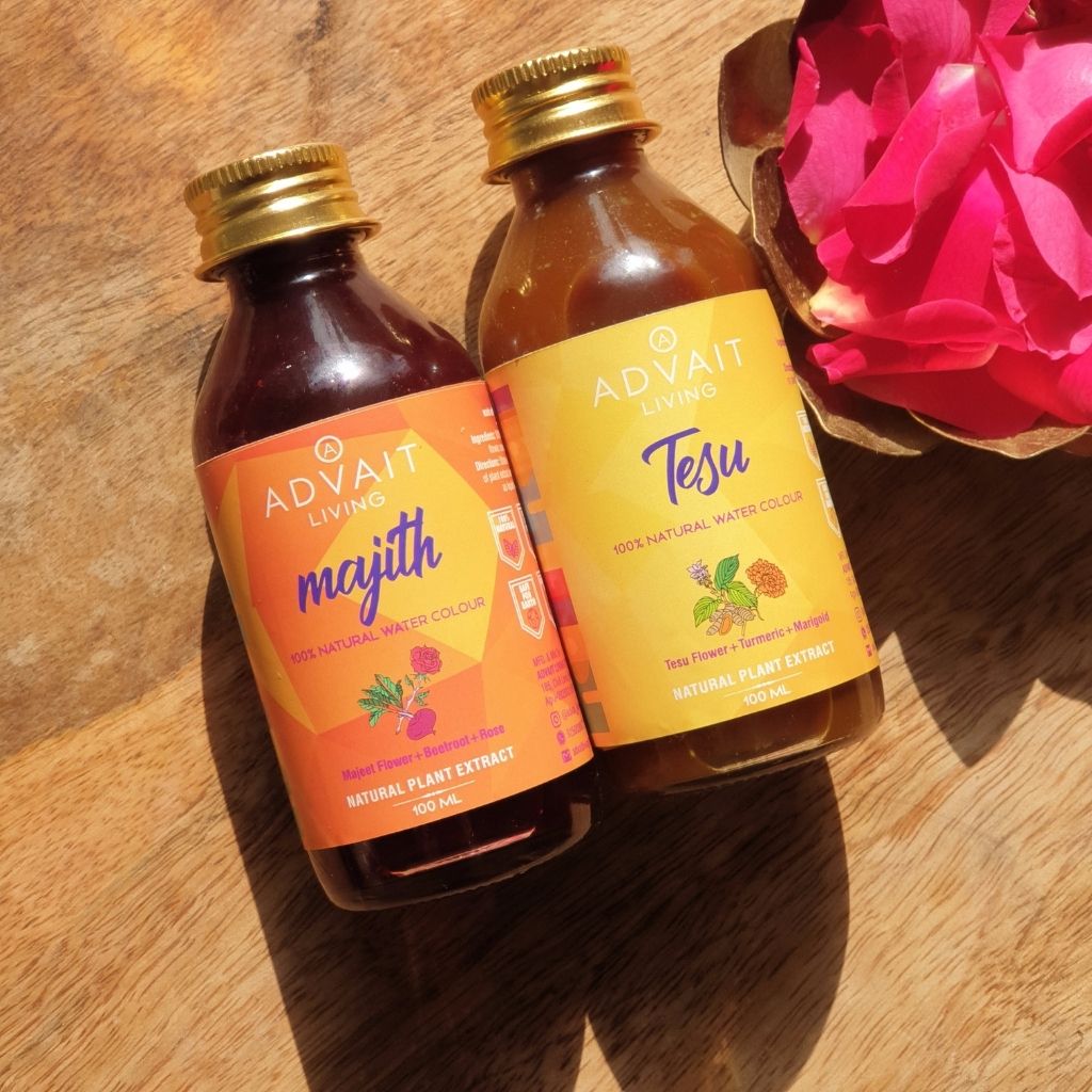 two holi liquid colour bottles on wooden board topview