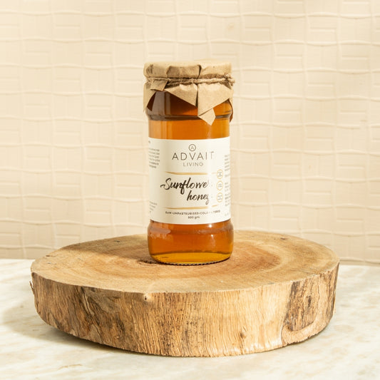 500 gm Advait Living Raw Sunflower Honey in a glass bottle.