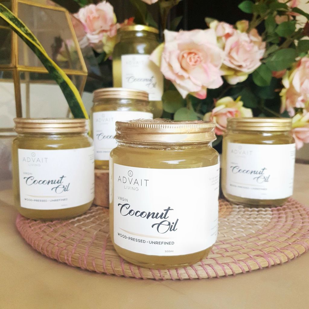 Four of Advait Living's 500 ml Coconut Oil Glass Bottles placed on a table